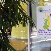 An einer Glasscheibe hängt ein Poster. Auf diesem steht: Sicher, Stark und Selbstbestimmt. Fachtagung 07. Juli 2017, 9.30 - 15.30 Uhr